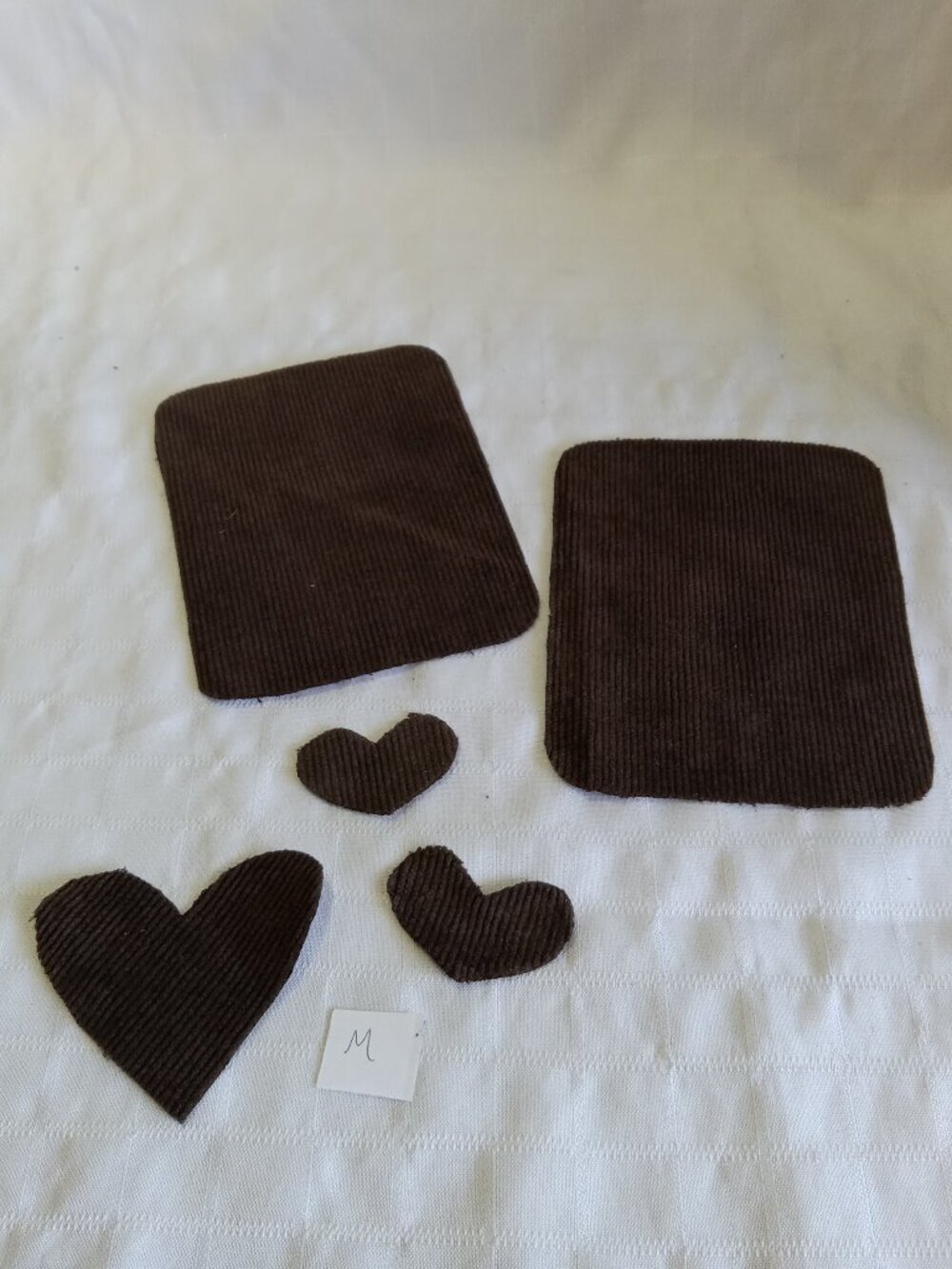 Two handmade elbow patches for sewing made of brown corduroy with hearts